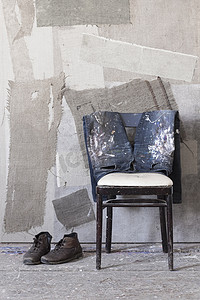 一双靴子脏牛仔裤放在椅子上墙上刷了漆