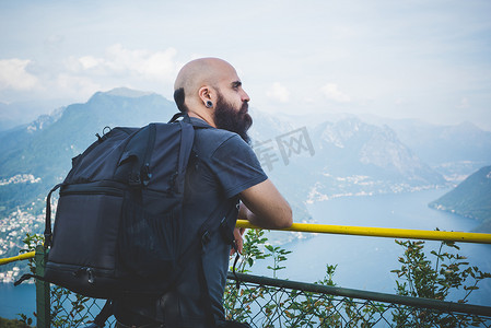 思考加一摄影照片_阳台上望着瑞士卢加诺湖的一名中年男子