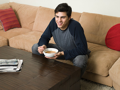 杂志社摄影照片_坐在沙发上喝汤的男人