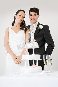 新婚夫妇站在婚礼蛋糕旁