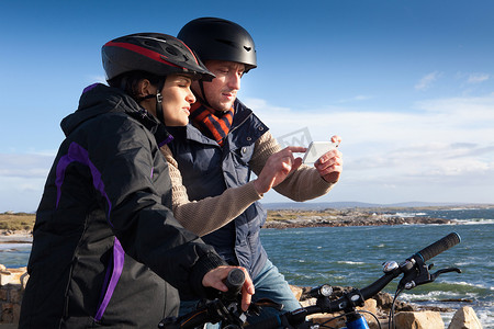 爱尔兰康涅马拉一对使用智能手机的自行车手夫妇