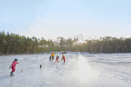瑞典一对老夫妇和孙子孙女在结冰的湖面上练习滑冰激流回旋