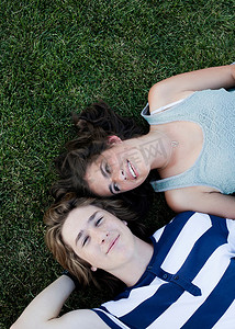 十几岁的少女摄影照片_一对十几岁的夫妇从上面躺在草地上