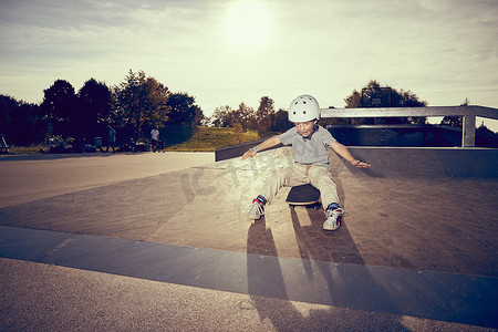 公园里坐在滑板上的男孩