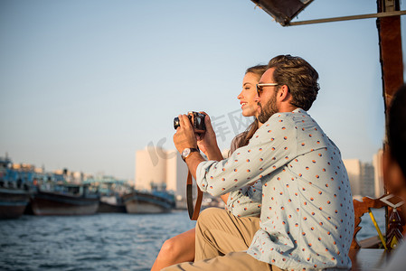 回顾摄影照片_阿联酋迪拜码头一对浪漫情侣在船上回顾镜头