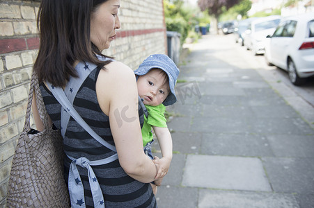 大家庭摄影照片_沿街母亲用婴儿吊带抱着男婴的肖像