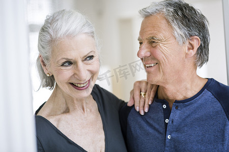 老年女性手搭在老年男性肩上微笑