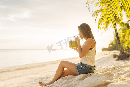 菲律宾博霍省安达海滩上喝着新鲜椰奶的年轻女子