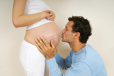 一名男子亲吻怀孕妇女的肚子