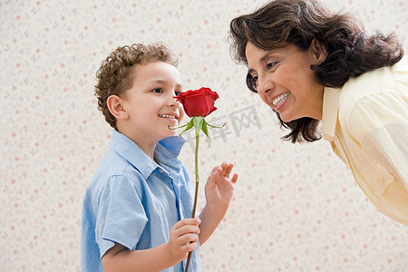 奶奶带孩子摄影照片_带着玫瑰的男孩给奶奶