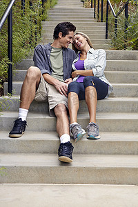 一双鞋运动鞋摄影照片_在台阶上拥抱的情侣