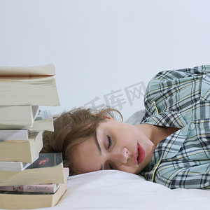 睡在书边的年轻女子