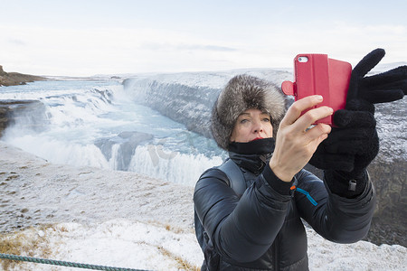 一加手机摄影照片_一名女子在位于冰岛西南部河峡谷的瀑布自拍