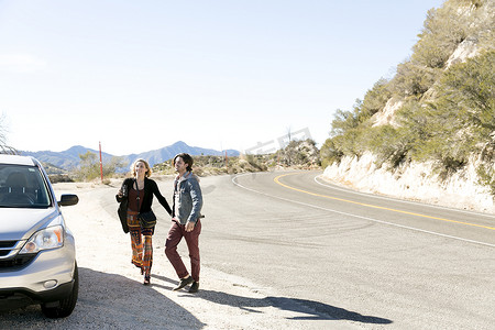 美国加利福尼亚州洛杉矶市奇劳露营地一对年轻夫妇在山路上开车微笑