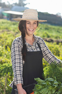 农名摄影照片_农场里种着蔬菜的年轻女子