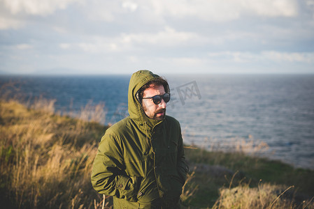 意大利撒丁岛萨萨里索尔索一名中年男子沿着多风的海岸漫步