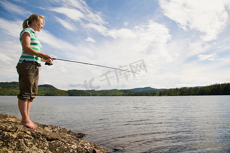 一名年轻女子在湖里钓鱼