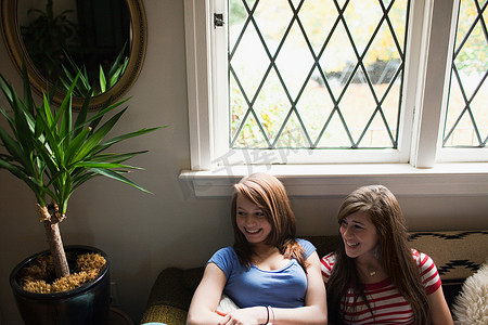 两个十几岁的女孩坐在窗边