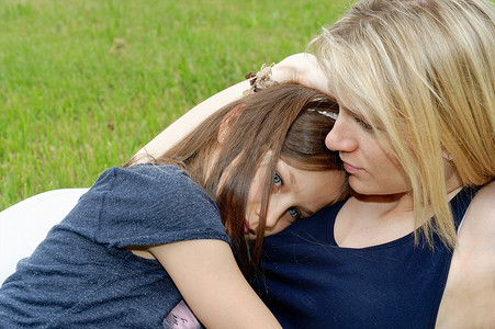女孩和母亲在公园拥抱的特写