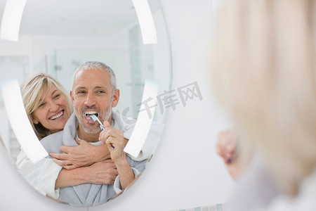 卫生间浴室镜摄影照片_男人和妻子一起刷牙