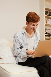 微笑的男人在客厅里使用笔记本电脑