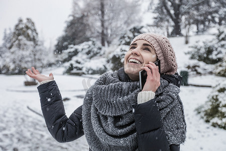 雪地上的一名女子用智能手机打电话