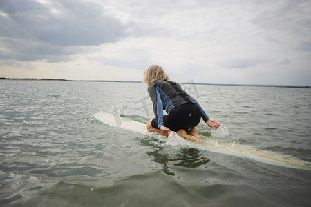 海上冲浪摄影照片_海上冲浪板上的资深女子冲浪板