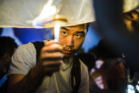 泰国清迈一名年轻男子为纸灯节点灯