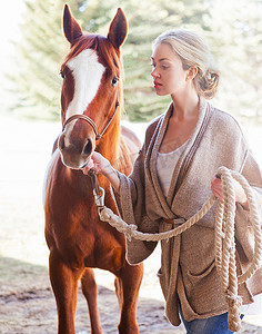 在农场照看马匹的年轻女子