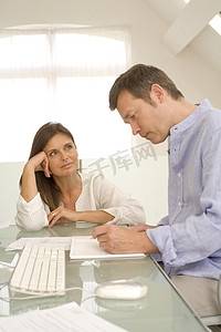 成熟的夫妇在家里的办公桌上查看账单和做文书工作