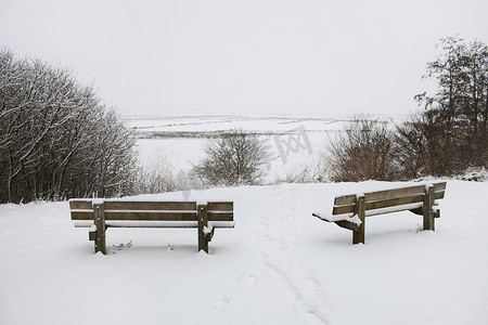两张乡村公园长椅眺望白雪覆盖的景色