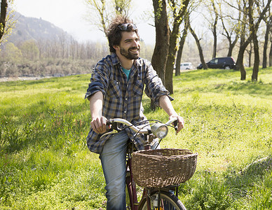 在乡村林地骑自行车的年轻人