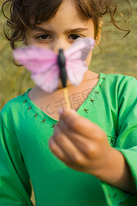 一个抱着一只玩具蝴蝶的女孩
