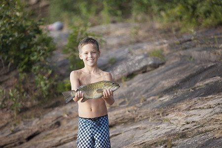 美国密歇根州火车湾区苏必利尔湖十几岁的男孩举着小口鳕鱼