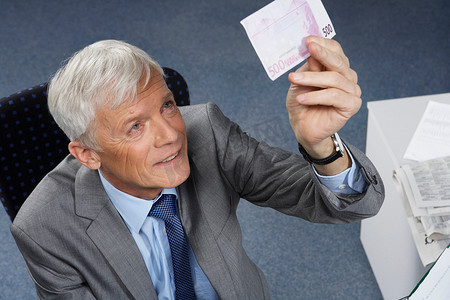 一位商人正在检查一张500欧元的钞票