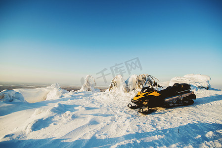 蓝天雪地摄影照片_雪地上停放的雪地车辆俄罗斯