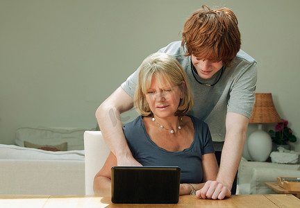 IT笔记本电脑摄影照片_儿子帮妈妈拿笔记本电脑