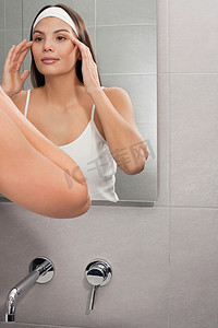 一名妇女在镜子中审视自己的脸