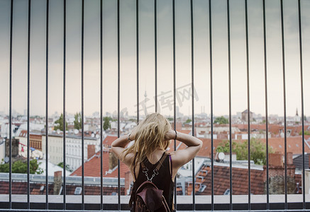 年轻女子隔着栏杆隔着屋顶看着风景看着后景