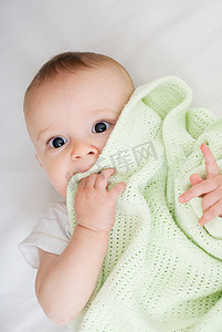 纯色床上用品摄影照片_裹着毯子的婴儿