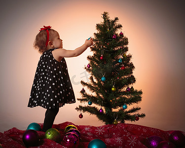良渚玉琮王纹样摄影照片_装饰圣诞树的小女孩