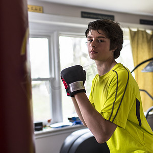 青少年搏击摄影照片_戴着拳击手套的十几岁男孩