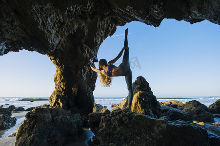 在美国加利福尼亚州洛杉矶海蚀洞年轻的女芭蕾舞演员单腿站立