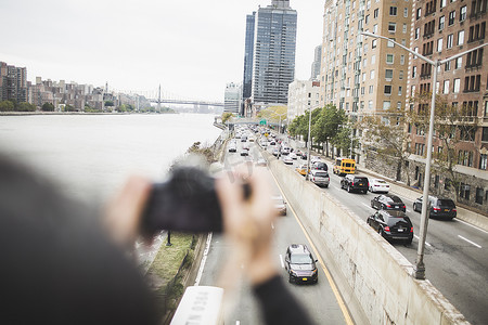 拍照旅游景点摄影照片_站在人行桥上的年轻女子拍照后视