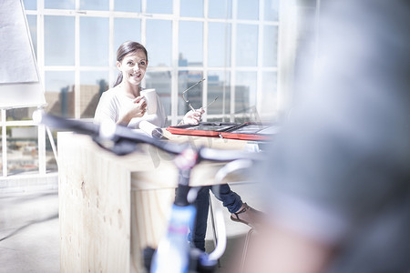 设计工作室露台上的女设计师与自行车快递员交谈