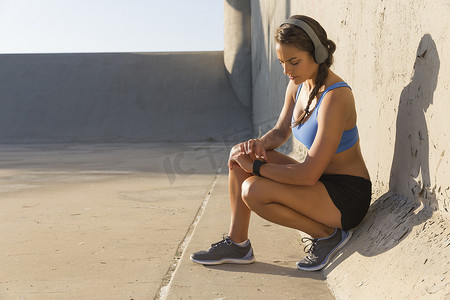 女运动员戴着耳机看智能手表