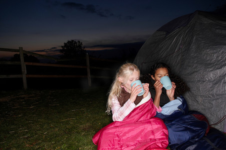 女孩们在帐篷附近喝着热饮