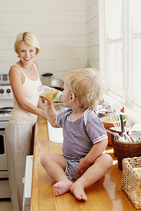 容器里的液体摄影照片_厨房里的母亲和孩子