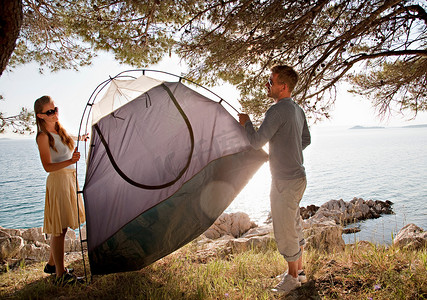 一对夫妇在海边搭帐篷