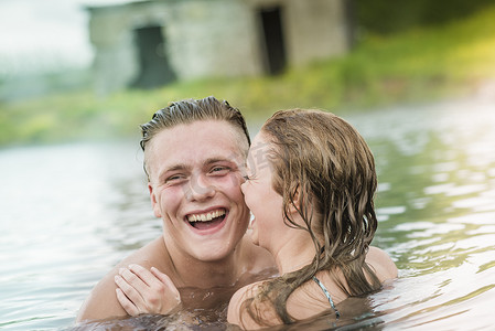 冰岛福夫迪尔年轻夫妇在秘密泻湖温泉里欢笑